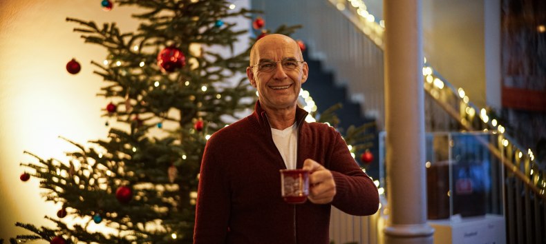 Chrtistoph Prinz mit einer Tasse Punsch vor dem Weihnachtsbaum im Kulturquartier, © Kulturquartier, Erik Swiatloch