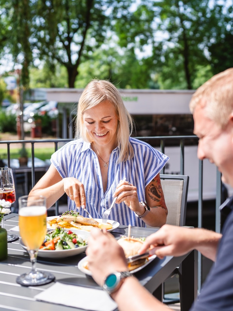 Essen im Restaurant Mahlwerk in der Kulturm&uuml;hle: Ein Paar genie&szlig;t ein Mittagessen im Freien des Restaurants Mahlwerk.