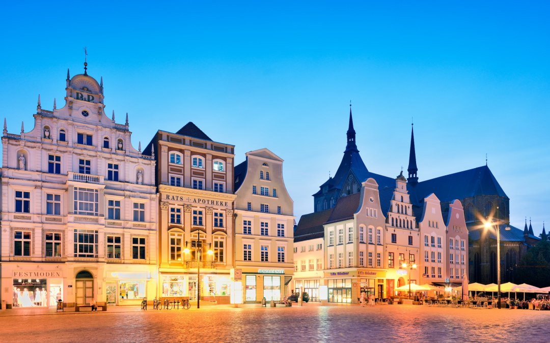 Der Neue Markt in Rostock leuchtet im Abendlicht: historische Fassaden, Kircht&uuml;rme und warme Fensterfl&auml;chen ziehen den Blick an und machen Lust auf einen Spaziergang durch Mecklenburg-Vorpommern. // &copy; Francesco Carovillano