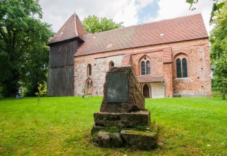 Dorfkirche seitlich mit Gedenkstein // &copy; Frank Burger