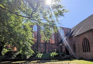 Johannisklsiter im Sonnenschein und Rosengarten im Vordergrund.
Anfang Mai // &copy; HANSESTADT Stralsund