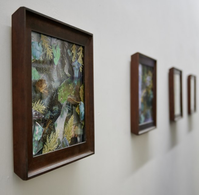 Besucher betrachten w&auml;hrend der Veranstaltungsreihe KUNST HEUTE gerahmte Naturcollagen in einer hellen Ausstellung.