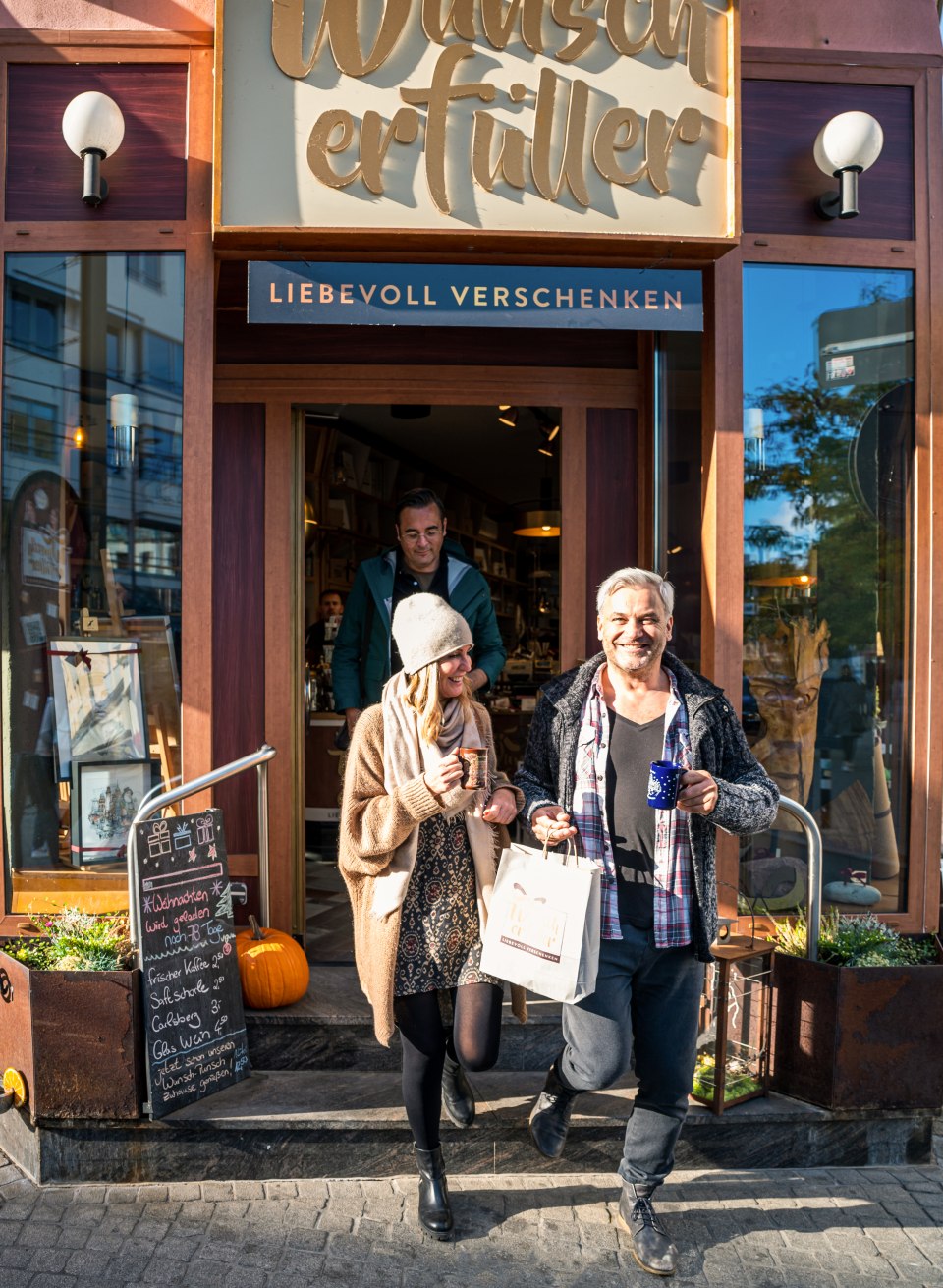 Twee mensen komen uit een winkel met volle boodschappentassen