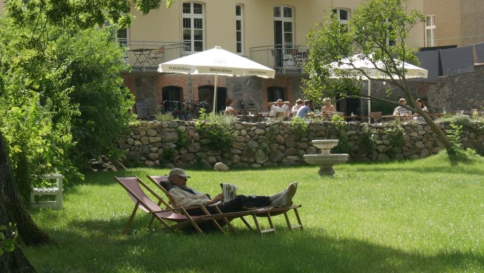 Gro&szlig;er Garten direkt am See mit Liegewiese, Seeterrasse und Ruderboot // &copy; Galeo Design/Schwesinger