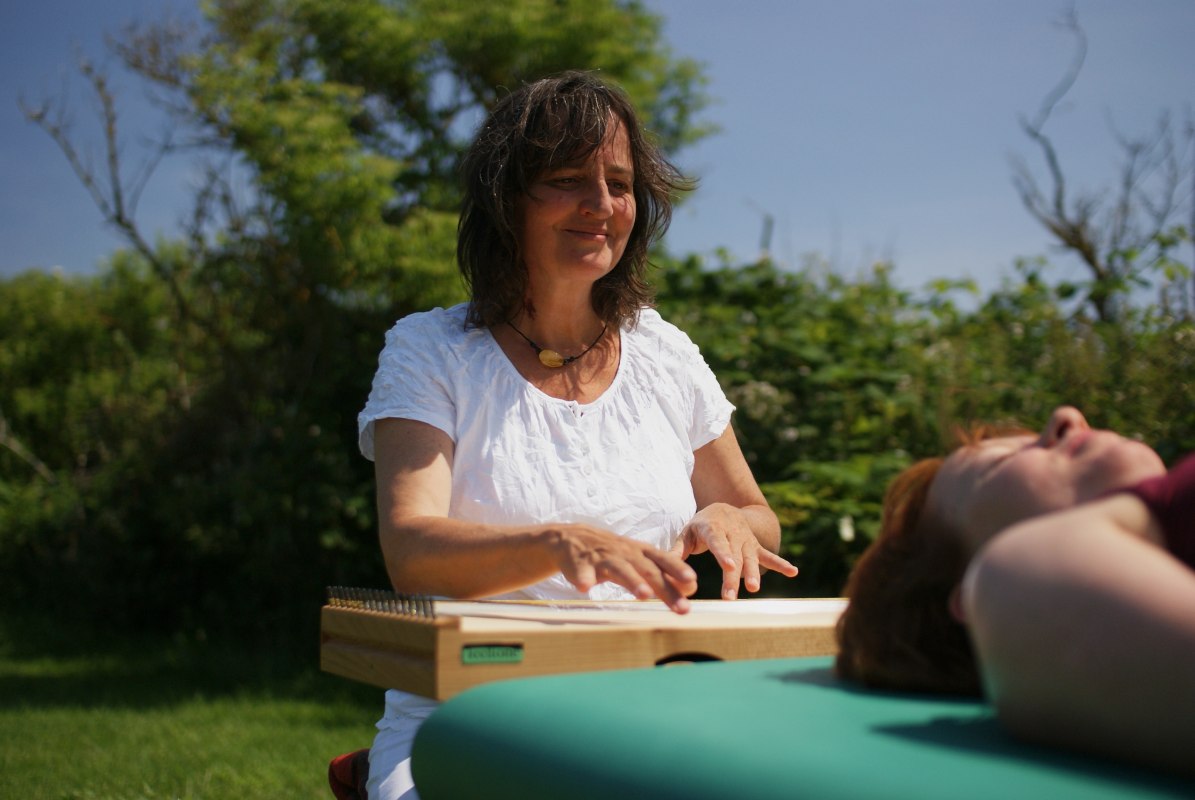 Martina Gl&auml;ser-B&ouml;hme spielend am Monochord - auf der Liege eine Klientin // &copy; Martina Gl&auml;ser-B&ouml;hme