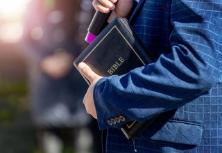 Ein Mann h&auml;lt eine Bibel in der Hand. // &copy; AdobeStock