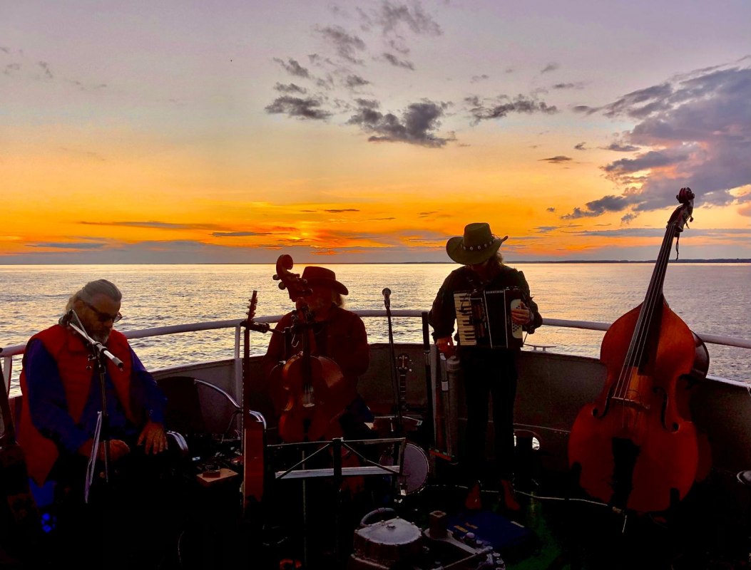 Die Irish Cowboys auf dem Heck von MS Nordost mit dem Sonnenuntergang auf dem Stettiner Haff im R&uuml;cken. // &copy; Sarah Stuth