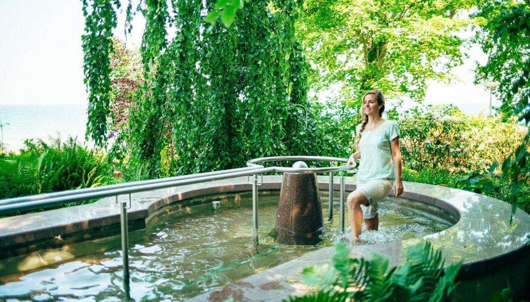 Eine Frau l&auml;uft in einem Kneipp-Wasserbecken umher.