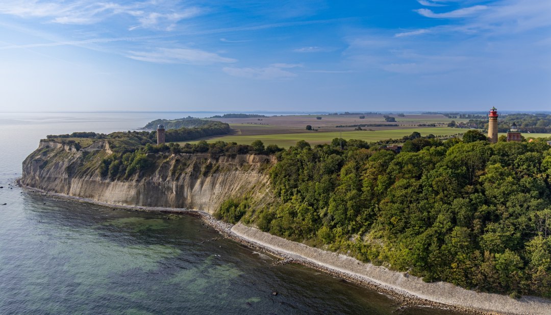 Luftaufnahme des Kap Arkona auf R&uuml;gen, mit seinen zwei Leuchtt&uuml;rmen und der steilen Kreidek&uuml;ste, umgeben von Feldern und der Ostsee unter klarem Himmel.