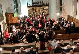Christa Maier (Mitte) mit Chor und Orchester  in der Dorfkirche Pinnow, hier eine Aufnahme vom vergangenen Jahr. // &copy; F&ouml;rderverein Pinnower Orgel e.V.