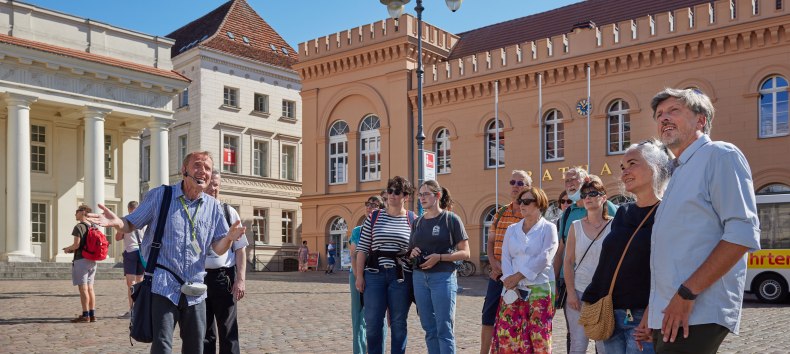 Stadtführer mit einer Gästegruppe auf dem Schweriner Markt vorm Rathaus., © Oliver Borchert Stadtführer mit einer Gästegruppe auf dem Schweriner Markt vorm Rathaus., © Oliver Borchert