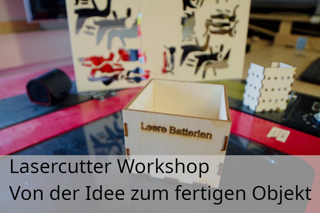 Gelaserte Box aus Sperrholz mit Beschriftung "Leere Batterien" im Hintergrund andere gelaserte Teile und der Lasercutter selbst, &copy; Hacklabor.de