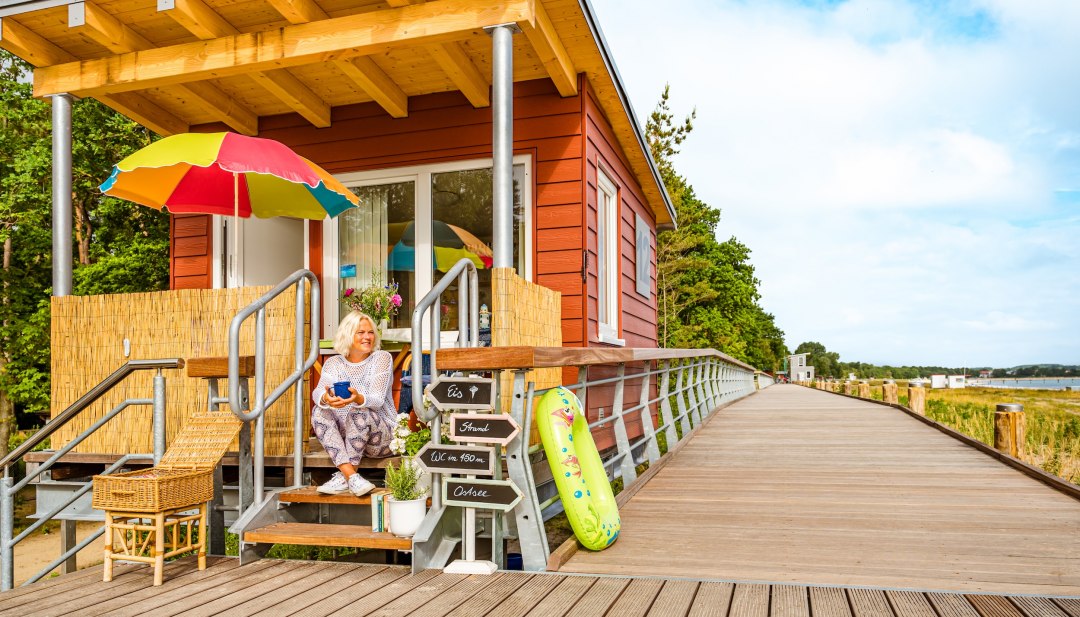 Eine Frau sitzt an der Promenade an ihrem kleinen Imbiss, an dem sie auch Strandk&ouml;rbe verleiht in Boltenhagen.