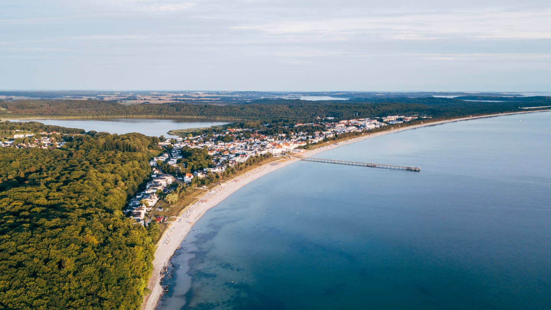 Der Strand und die Promenade von Binz aus der Luft mit Seebrücke und einem Teil der Ostsee zum Sonnenaufgang // Unübersehbar schön, der Strand und die Promenade mit der Binzer Seebrücke auf Rügen // © MV-T/Gänsicke Der Strand und die Promenade von Binz aus der Luft mit Seebrücke und einem Teil der Ostsee zum Sonnenaufgang
