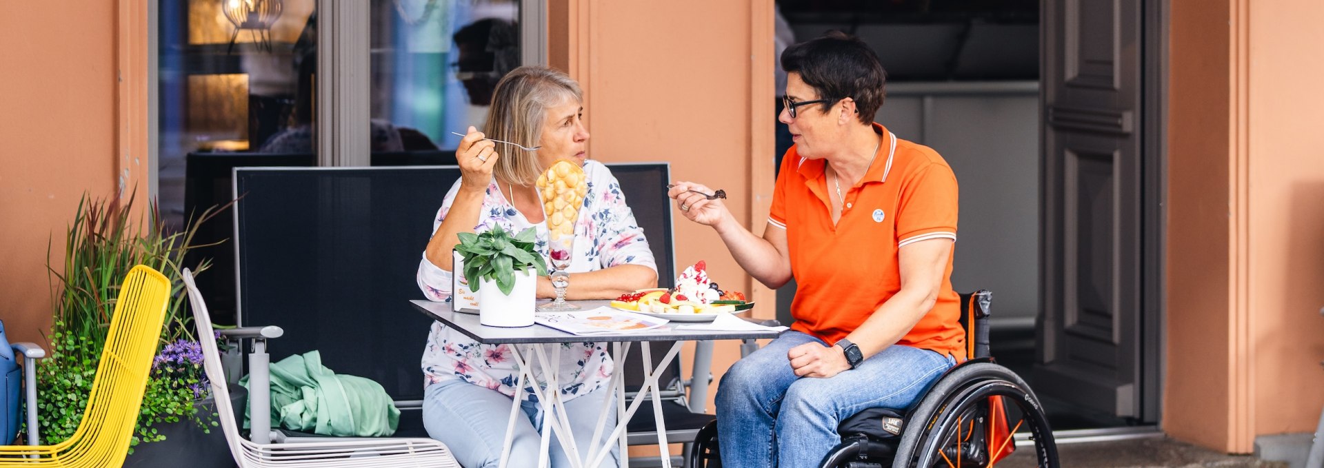 Kerstin en Angelika trakteren zichzelf op een zoete snack in de Al Ponte ijssalon - drempelvrij.