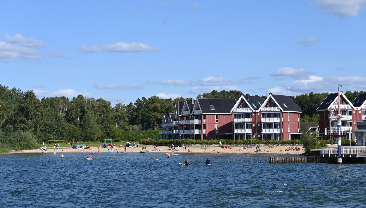 Startpunkt für Schwimmer, Surfer und SUPler: Der Badestrand im Hafendorf Müritz verfügt über eine kleine Seebrücke, eigene Sanitäranlagen und eine Freiluftdusche., © KUHNLE-TOURS Startpunkt für Schwimmer, Surfer und SUPler: Der Badestrand im Hafendorf Müritz verfügt über eine kleine Seebrücke, eigene Sanitäranlagen und eine Freiluftdusche., © KUHNLE-TOURS