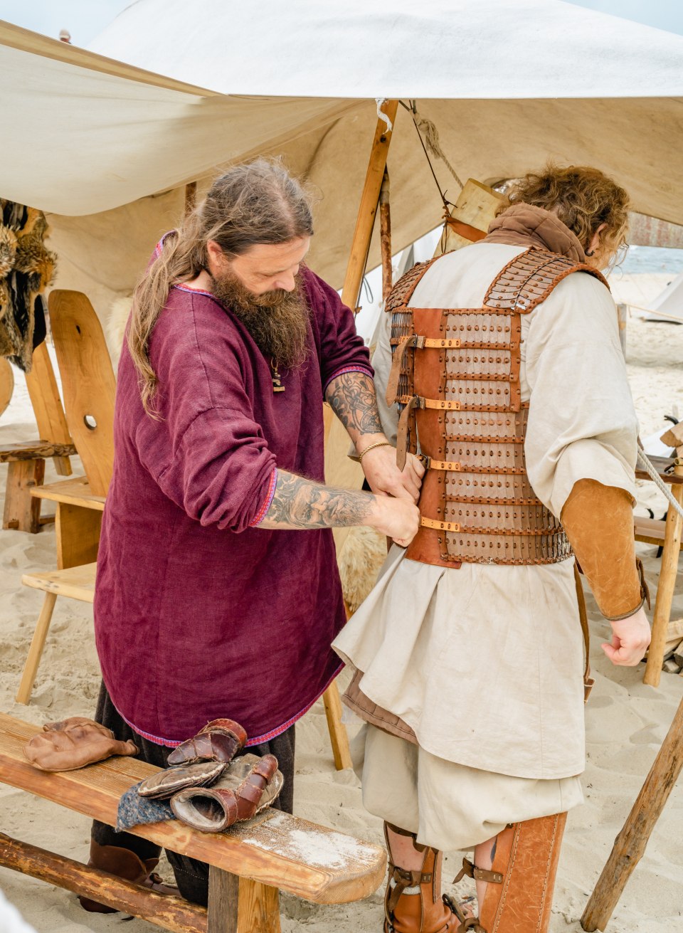Anziehen eines Wikingergewandes mit Rüstung beim Wikingerfest in Göhren. // Bis zu zwanzig Kilogramm wiegen die Gewänder der Kämpfer – da dauert es schon mal, bis sie mit der Hilfe der eigenen Sippe angelegt werden // © MV-T/Tiemann Anziehen eines Wikingergewandes mit Rüstung beim Wikingerfest in Göhren.